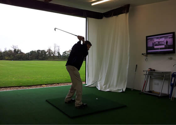 Golfer driving in an outdoor academy