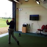 Golfer hitting out from inside the teaching bay